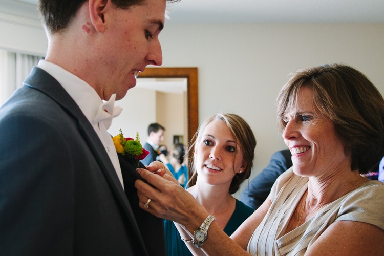 groom's mother pins boutonniere