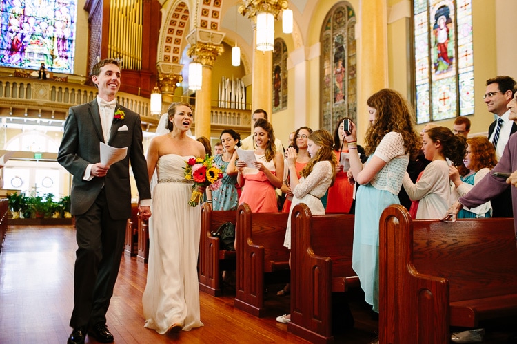 bride and groom sing while they process to their wedding ceremony at St. Cecilia's, Boston