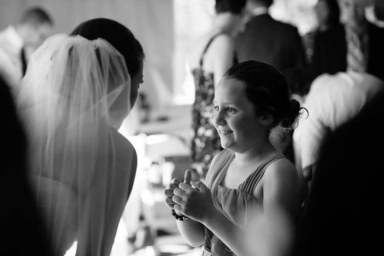 bride greets young guest in tent at Community Rowing