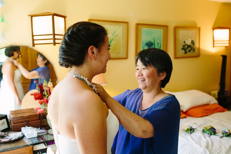 mother adjusts bride's necklace