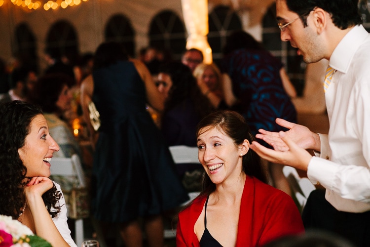 guests laugh during wedding reception