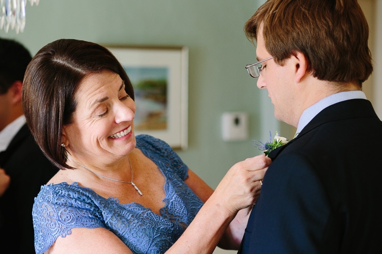 groom's boutonniere is pinned by his mother, at their home in Duxbury, Massachusetts