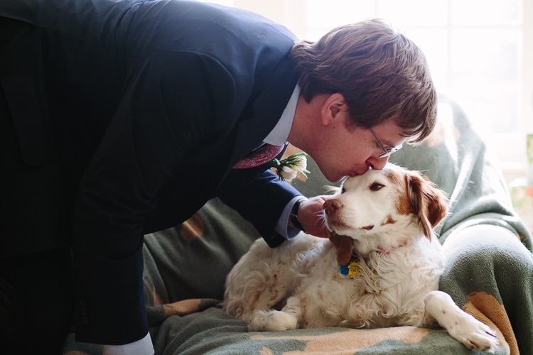 groom kisses his dog before departing for the wedding