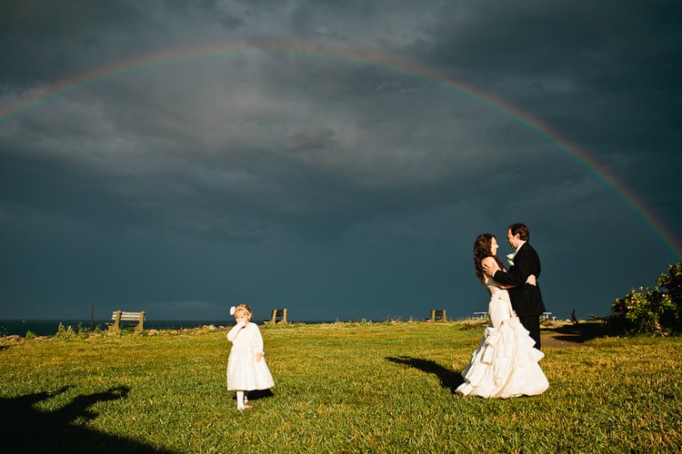 bride and groom under rainbow