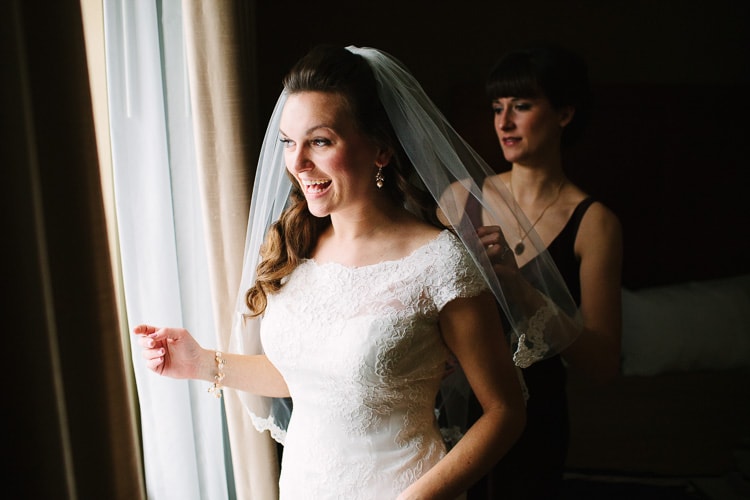 bride dressing in beautiful window light