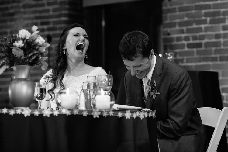bride and groom laugh during toasts