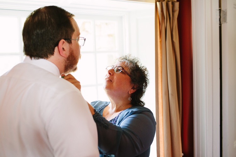 mother of the groom adjusts his bowtie, image by Kelly Benvenuto
