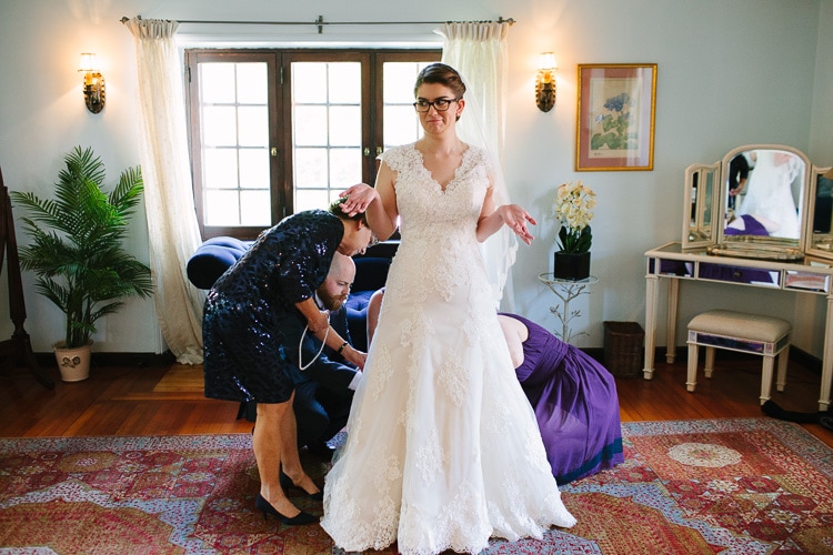 bride reacts to attendants fussing with her bustle, image by Kelly Benvenuto