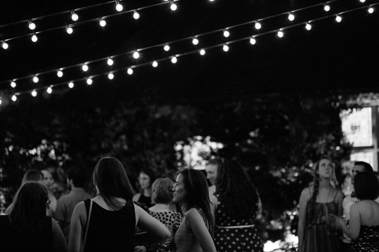 guests under bistro lights in willowdale estate courtyard, photo by Kelly Benvenuto