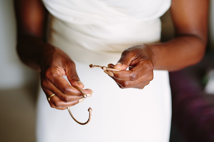 wedding detail of gold bangles in bride's hands