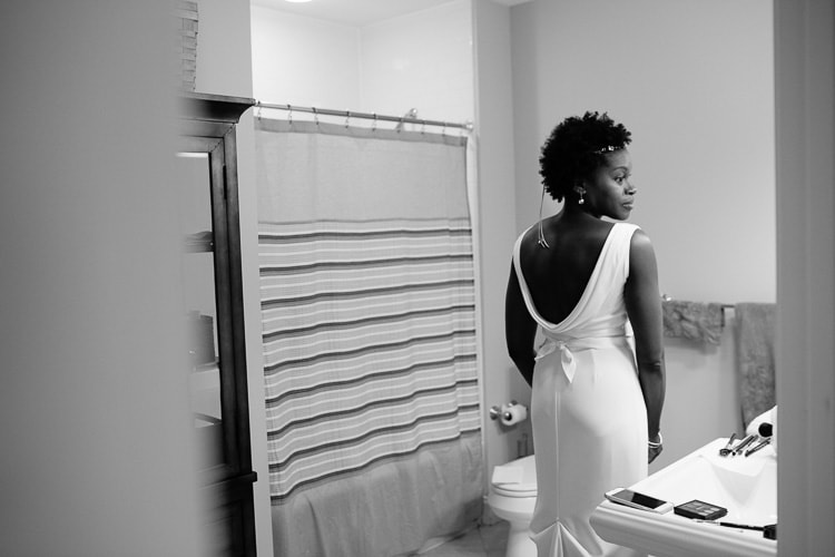 bride views herself in bathroom mirror