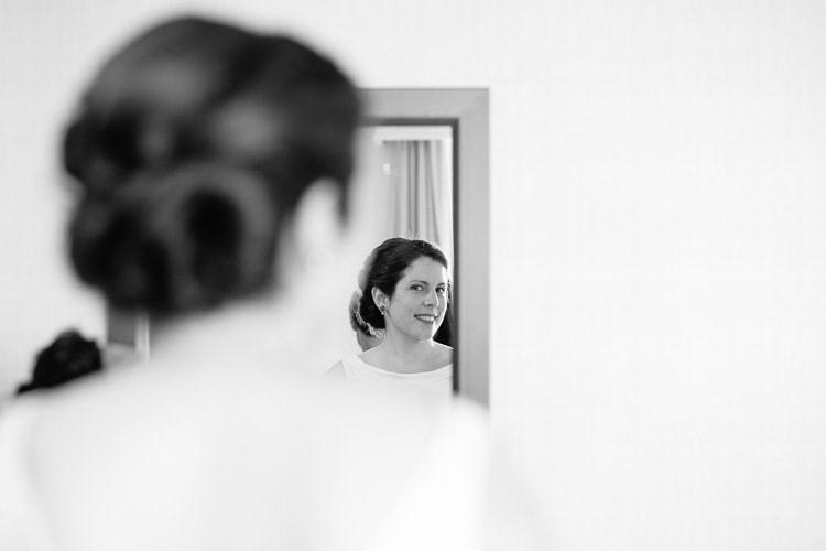 bride Anna checks her appearance in the mirror at the Cambridge Royal Sonesta