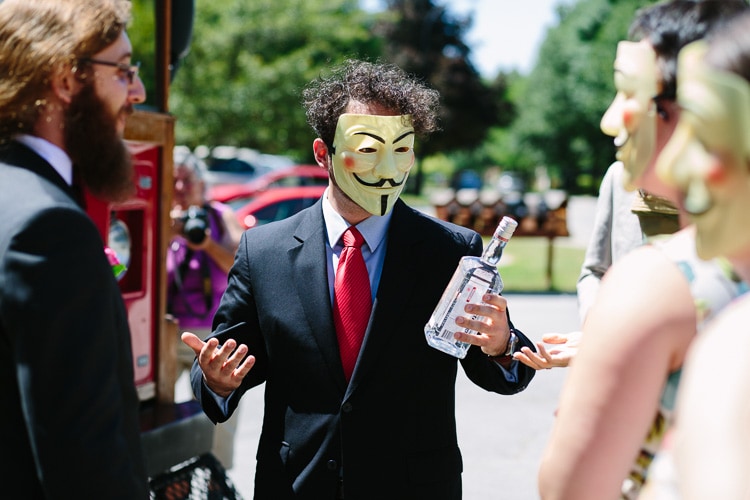 guest in Guy Fawkes mask accepts bottle of vodka as payment to allow bride and groom to go to church, Polish wedding tradition