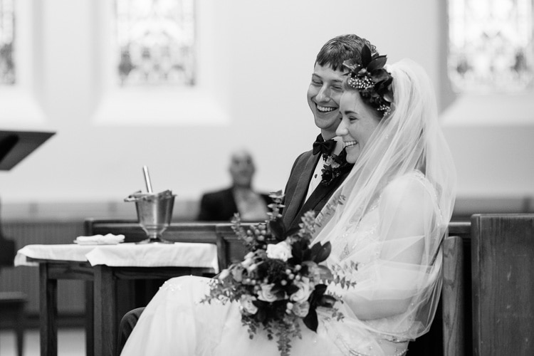 bride and groom laugh during wedding service