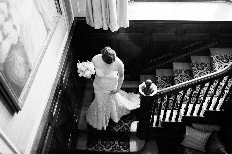 classic black and white wedding image, bride descending stairs, photo credit Kelly Benvenuto