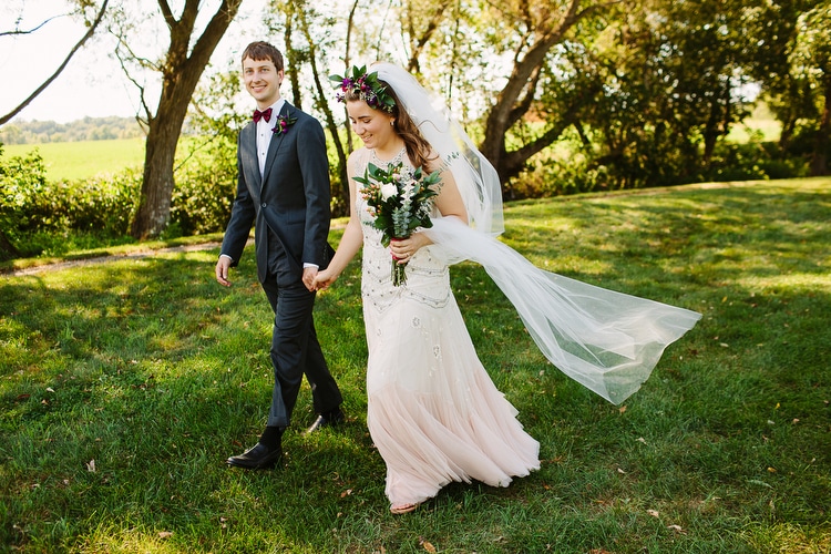 Bride and groom walk hand in hand in this relaxed wedding portrait by Boston wedding photographer Kelly Benvenuto.