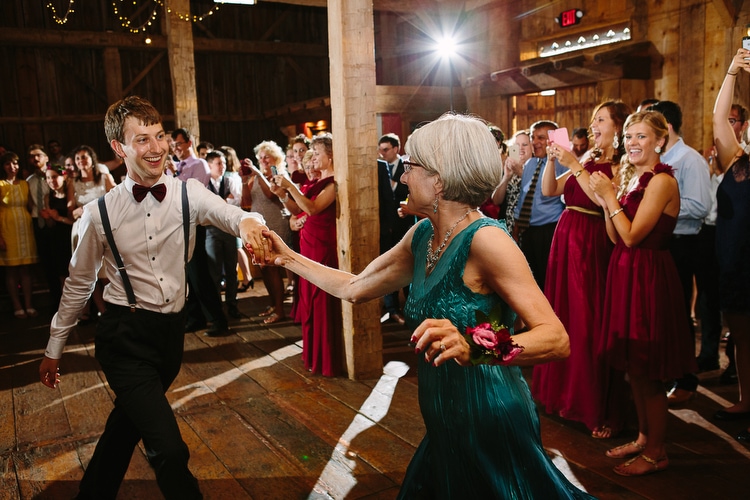 Mother-son dance during barn wedding reception. Candid wedding photography by Kelly Benvenuto.