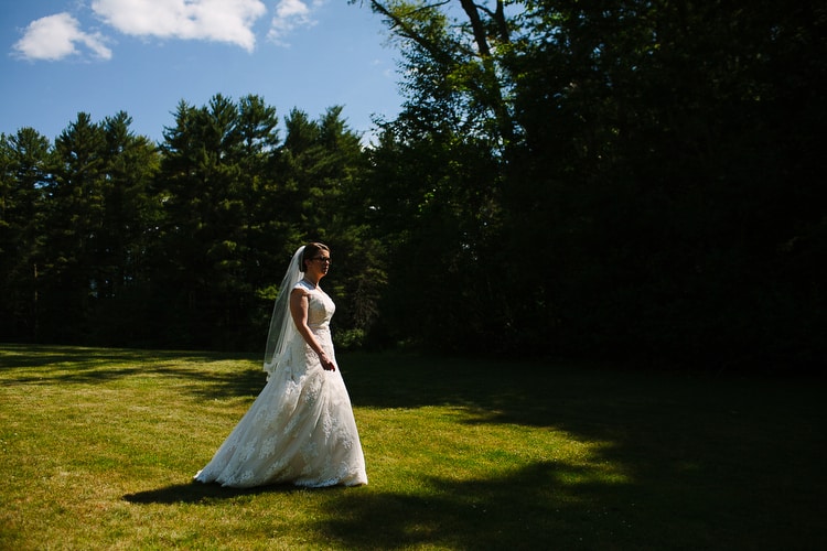 Bride walking across the lawn of Willowdale Estate on her way to her first look with the groom. Vibrant, natural wedding photography in Boston by Kelly Benvenuto.