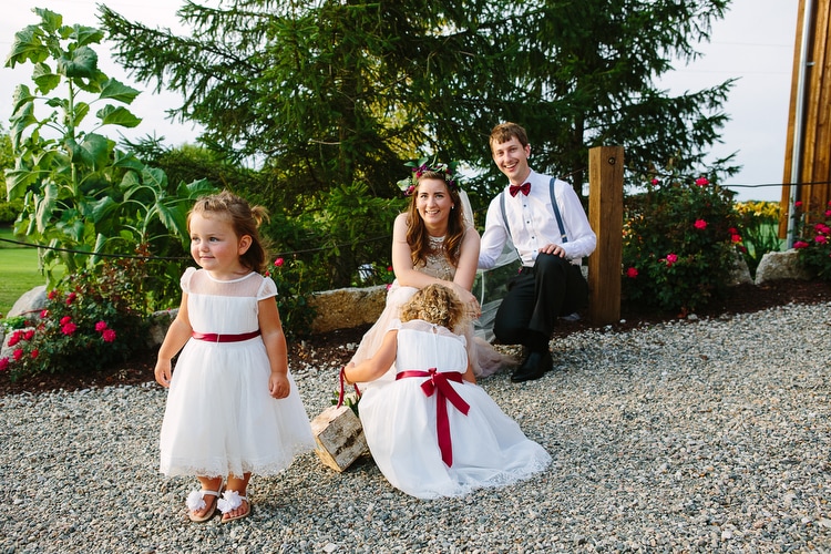 Bride and groom with distracted flower girls. Natural and candid wedding photography by Kelly Benvenuto, serving Boston and beyond.