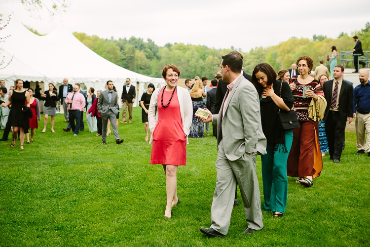Guests walk to outdoor wedding ceremony on the grounds of Friendly Crossways in Harvard, MA. Documentary wedding photography in Boston and New England. Photo by Kelly Benvenuto.