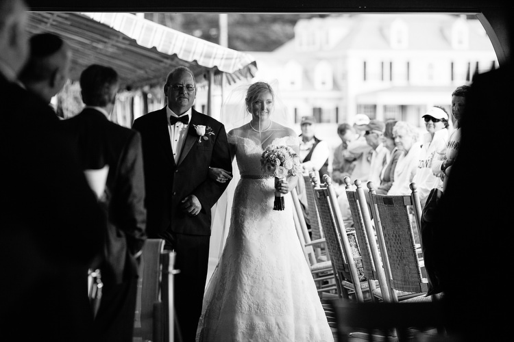 Classic, black and white image of bride walking down the aisle at the Corinthian Yacht Club in Marblehead, MA. Artistic, documentary in Boston and New England. Photo by Kelly Benvenuto.