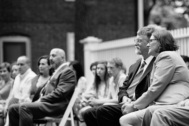 Parents hold hands during wedding ceremony. Boston wedding photojournalism. Image by Kelly Benvenuto.