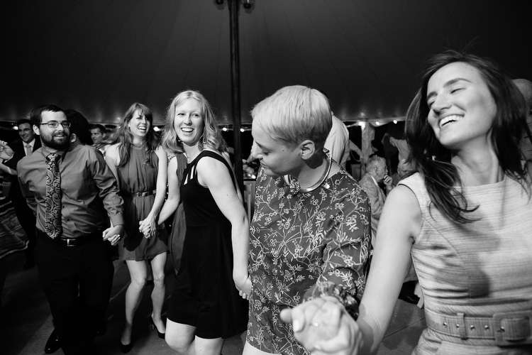 Guests dance during tented wedding reception. Image by Boston documentary wedding photographer Kelly Benvenuto.