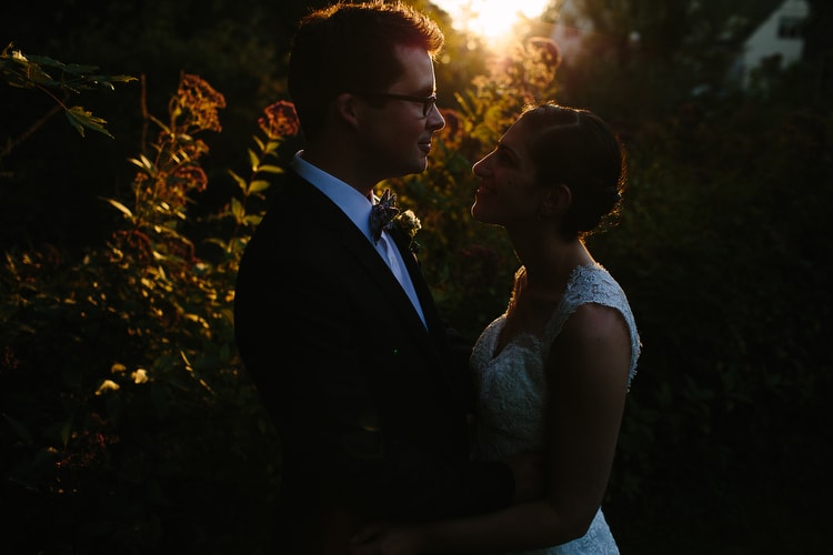 Romantic, artistic golden hour wedding portrait, on the grounds of the Meetinghouse in Tiverton, Rhode Island. Image by Kelly Benvenuto.