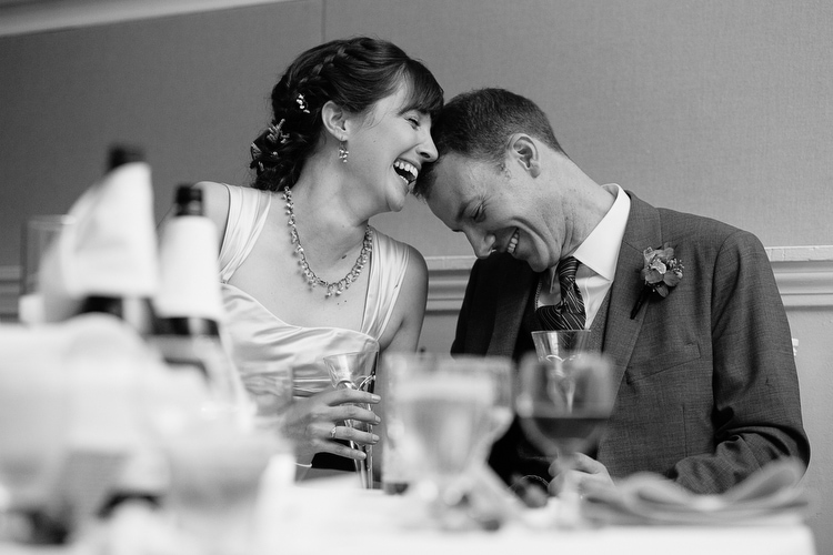 Bride and groom share a laugh during wedding toasts. Candid, emotional wedding photography in Boston and New England by Kelly Benvenuto.