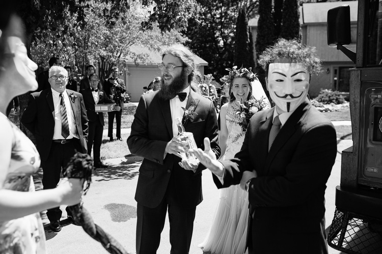 Guy Fawkes blocks the wedding party's departure for the church. Black and white wedding photojournalism by Boston and New England wedding photographer Kelly Benvenuto.