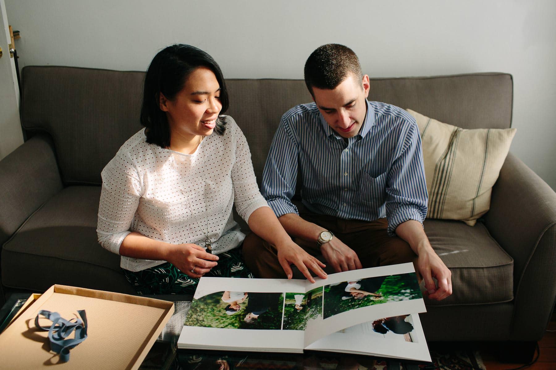 couple views wedding album for first time