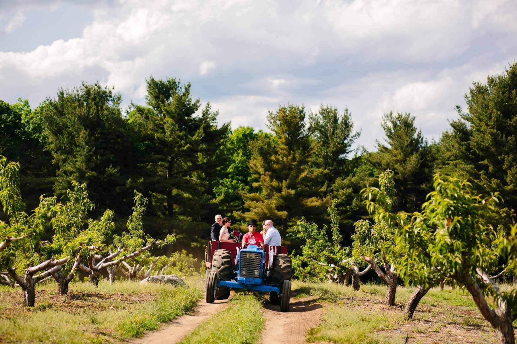 bride with family on hayride to ceremony at Red Apple Farm, Phillipston, MA