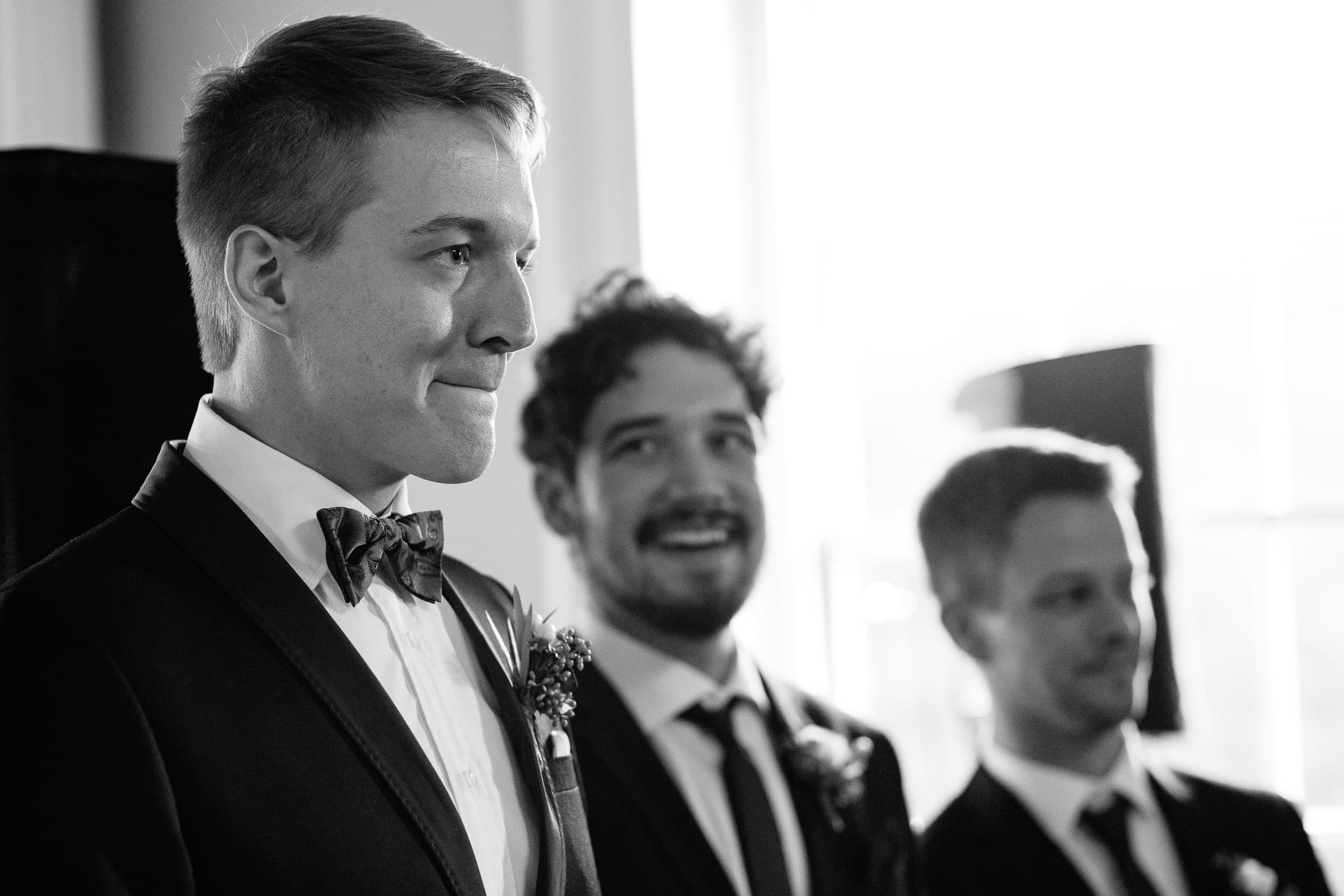 groom reacts to seeing bride walk down the aisle | indoor wedding ceremony at the Lyman Estate, Waltham, MA | emotional Boston wedding photographer | Kelly Benvenuto Photography