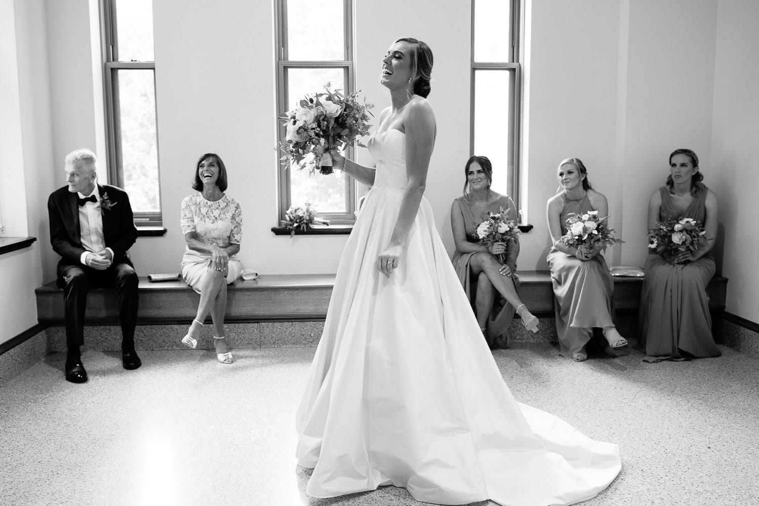 bride laughs in anticipation of seeing groom for first look in Stokes Hall, Boston College