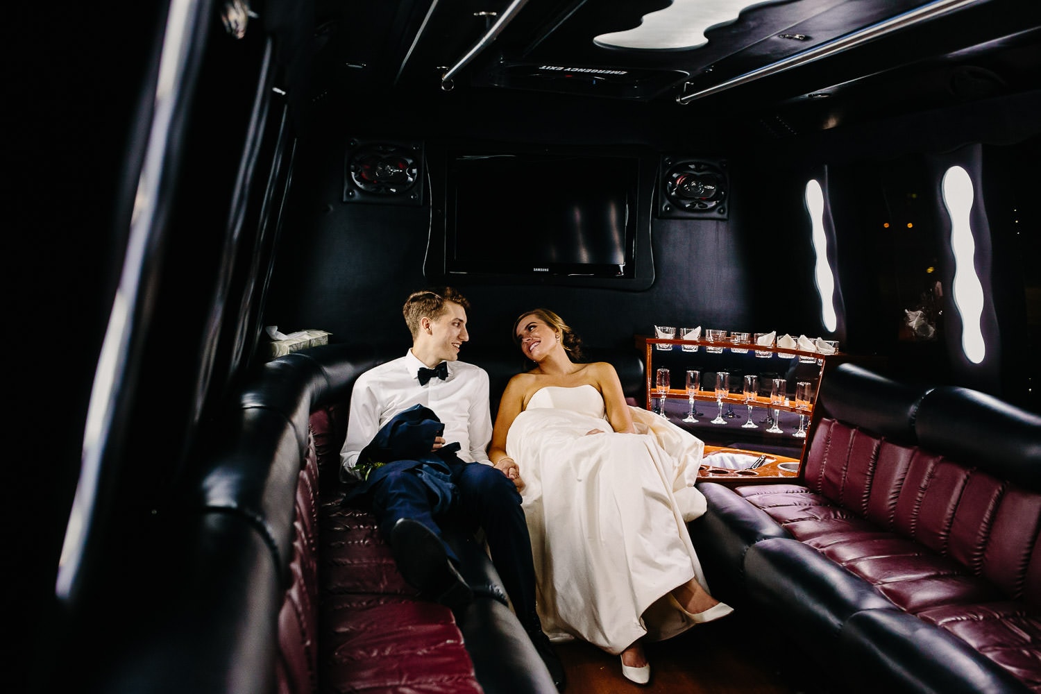 bride and groom in back of party bus